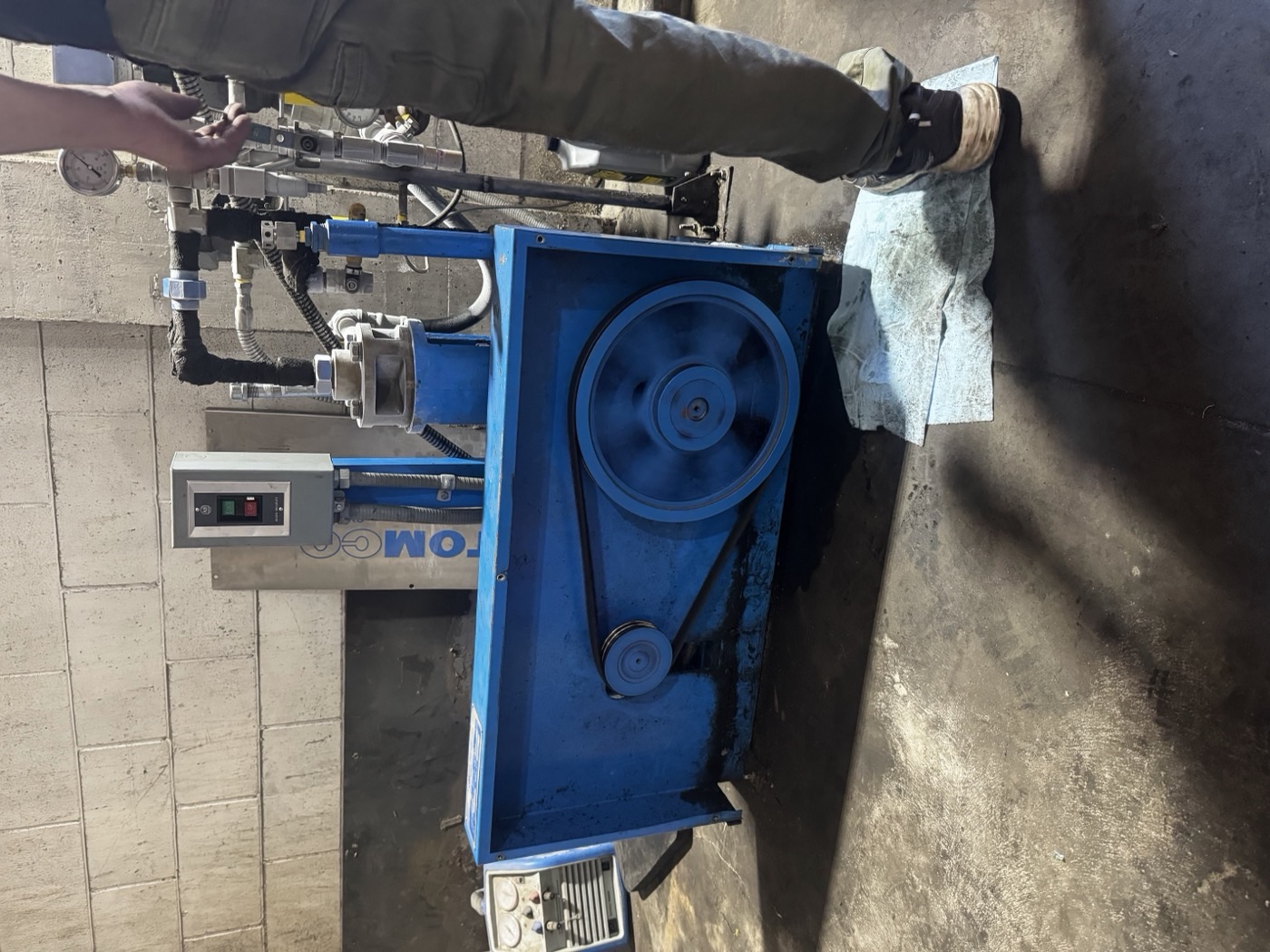 Operator running the CO2 transfer pump during a same-day tank refill at Quality Beverage, Fresno